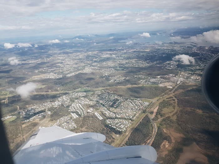 Wide photograph looking down at Gladstone city, Queensland, from window seat of airplane